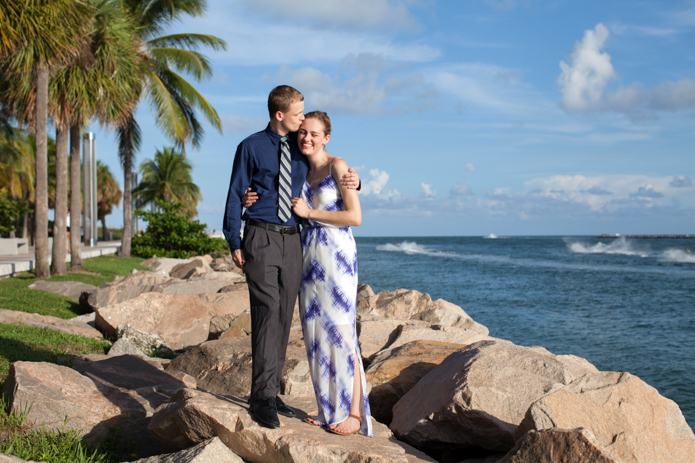 couple embracing lovingly on the rocks at south pointe park
