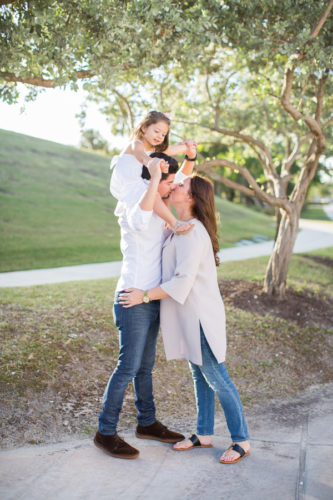 Family of three kissing miami beach