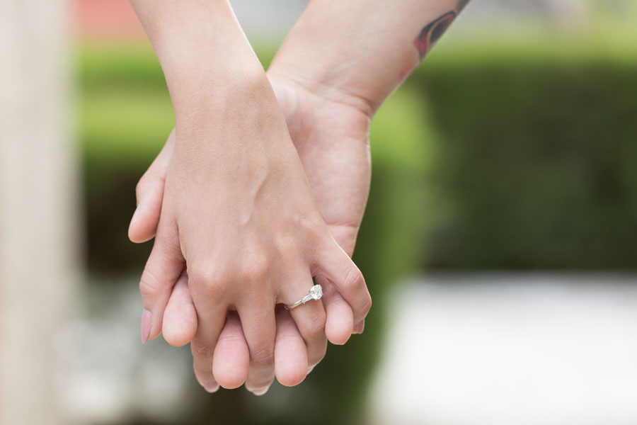 holding hands with engagement ring