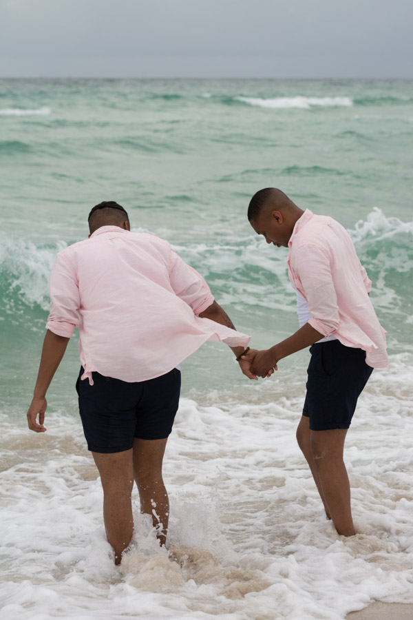 couple holding hands going into the ocean