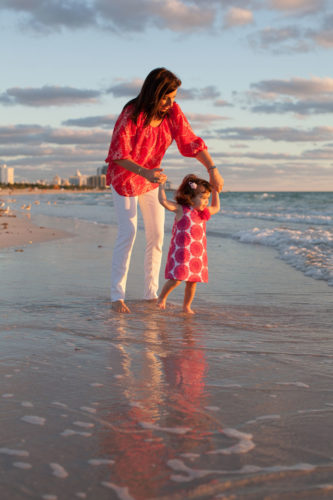 mother holding daughter at beach