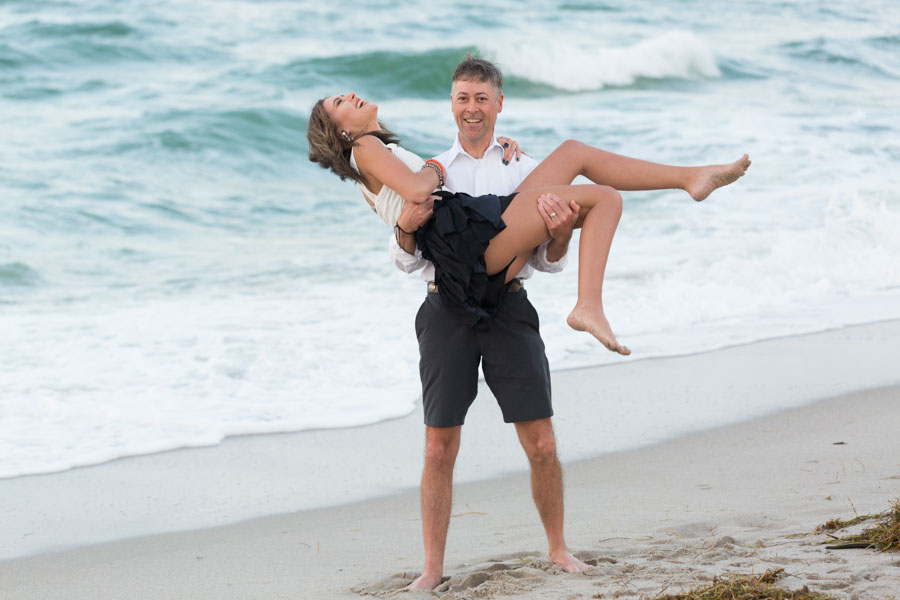 Father lifts daughter on beach