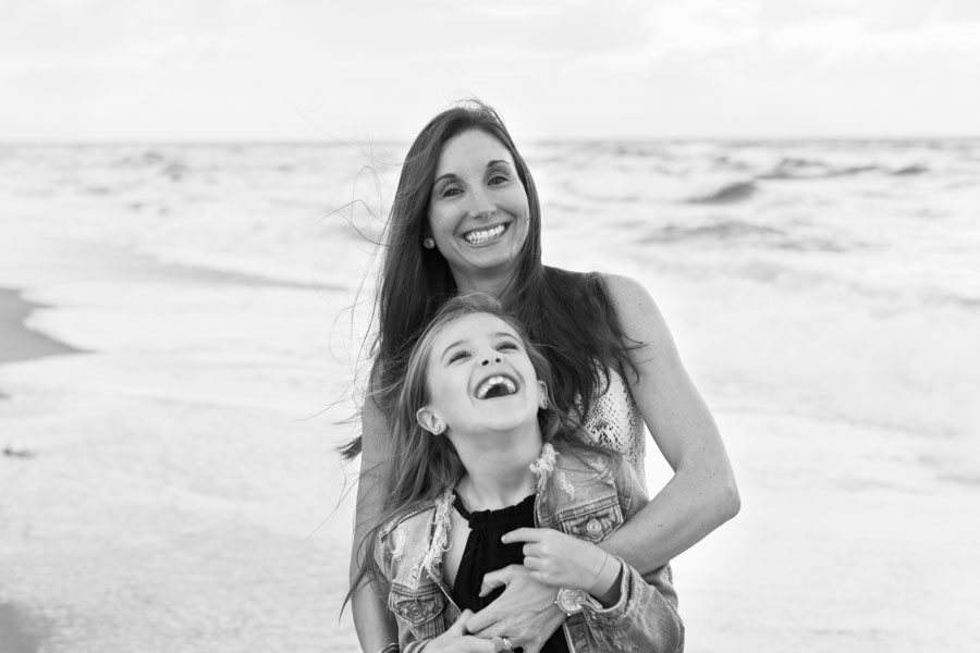 mother daughter laughing on beach in black and white