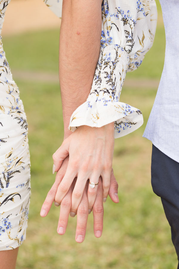 couple holding hands engagement ring