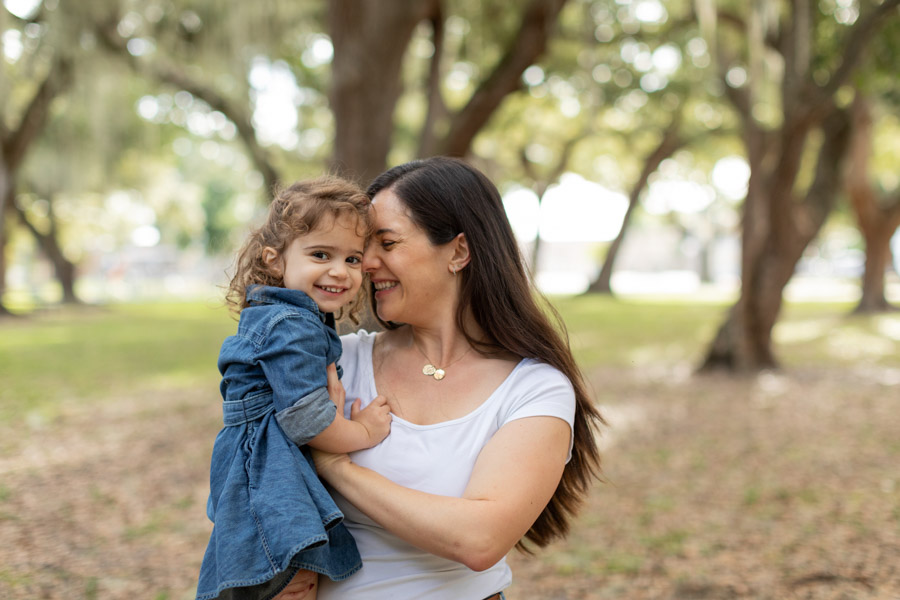 mother holding daughter and smiling