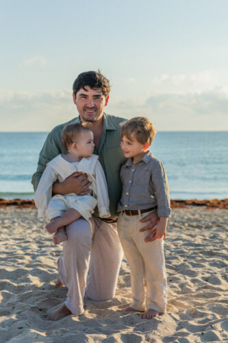 father with two kids on beach